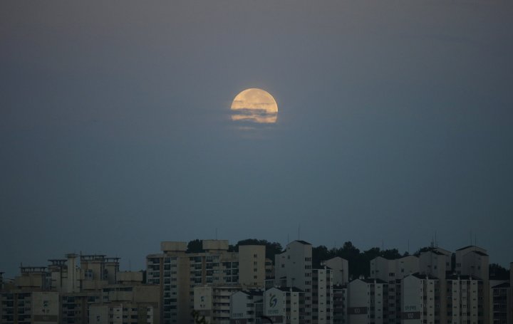 Луна над жилым массивом в городе Сувон, Корея. ©REUTERS