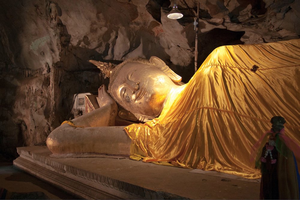 Лежащий золотой Будда в пещерном храме в окрестностях Хуа-Хина.
