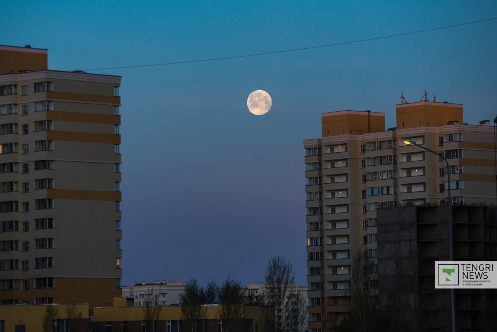 Луну еще отчетливо видно над городом, но скоро она исчезнет. Фото Турар Казангапов ©