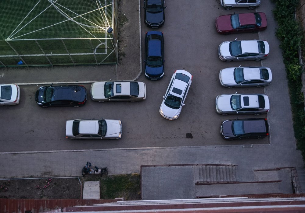 На часах 8 вечера, автомобили начинают постепенно заполнять двор, образуются небольшие заторы. Наш разговор прерывает громкий, пронизывающий сигнал. Водители не хотят уступать друг другу. Фото Турар Казангапов©