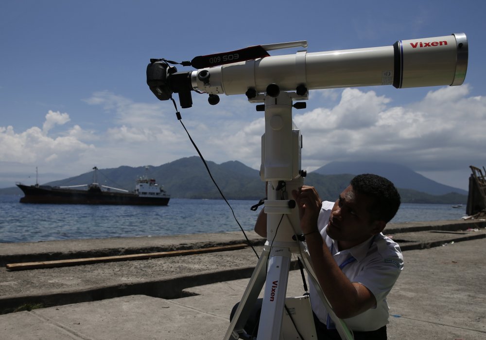 Индонезийское агентство по метеорологии, климатологии и геофизике готовит объектив для записи солнечного затмения на пляже. Индонезия. © REUTERS
