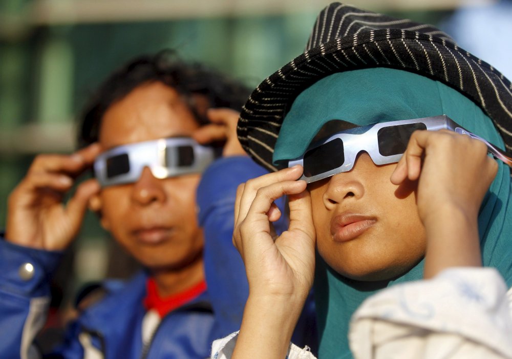Люди наблюдают солнечное затмение. Джакарта, Индонезия. © REUTERS