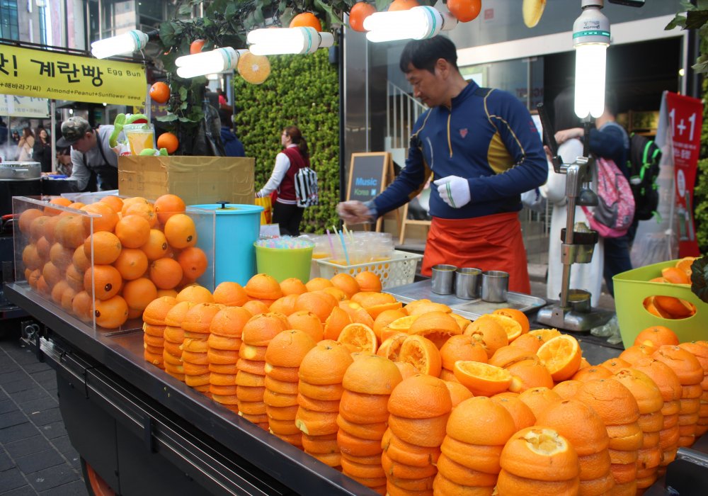 Тут же можно купить стакан свежевыжатого апельсина. Точно такие же прилавки есть с арбузами и гранатом. Стаканчик сока стоит от 4 до 6 тысяч вон - примерно 1500 тенге.