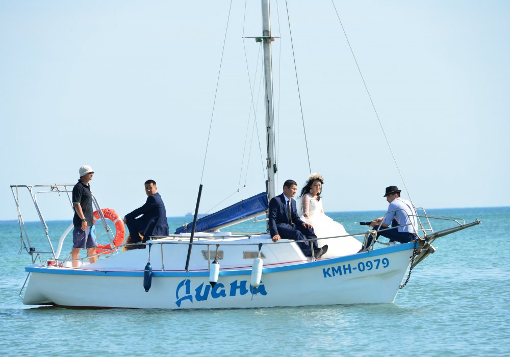 Молодожены Актау с интересом наблюдали за действиями столичных журналистов в море.