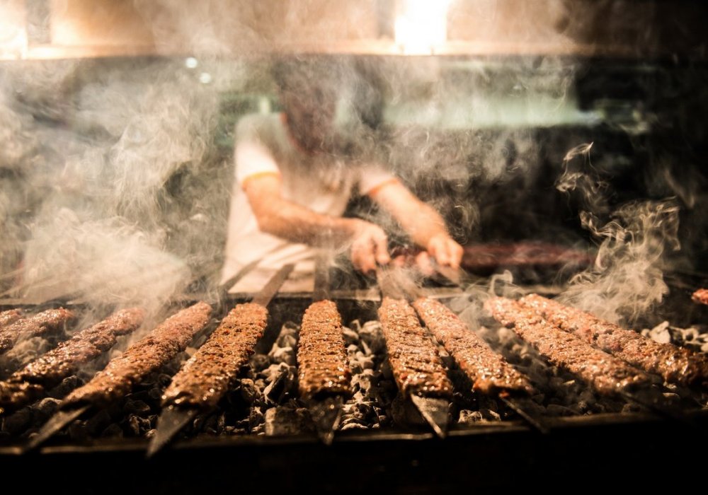 Адана кебаб - жареный бараний фарш на шампурах. Его подают с поджареными овощами и лепешками