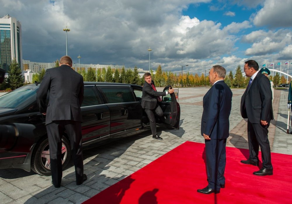 Автомобиль Путина не успел остановиться,  как тут же из него буквально выпрыгнули люди в черном. Они торопились, чтобы открыть дверь своему шефу.