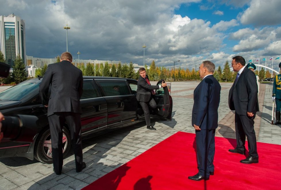 Автомобиль Путина не успел остановиться,  как тут же из него буквально выпрыгнули люди в черном. Они торопились, чтобы открыть дверь своему шефу.