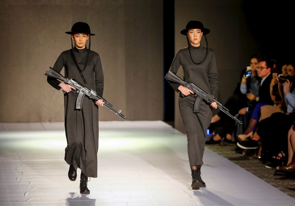 <p>Модели дефилируют по подиуму с автоматическим оружием в руках во время показа коллекции казахстанского дизайнера на неделе моды в Алматы. Фото REUTERS/Shamil Zhumatov&copy;</p>