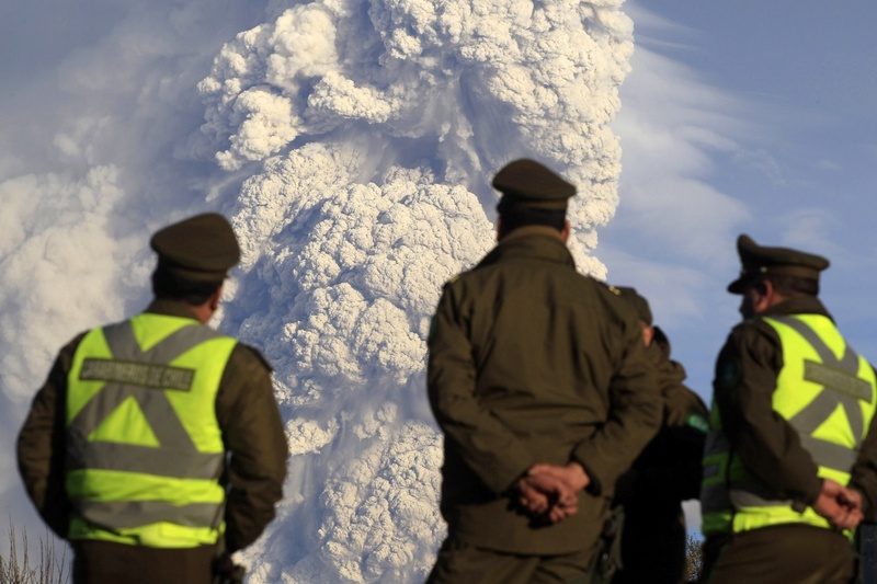 Чилийские полицейские наблюдают за извержением вулкана. ©REUTERS/Ivan Alvarado