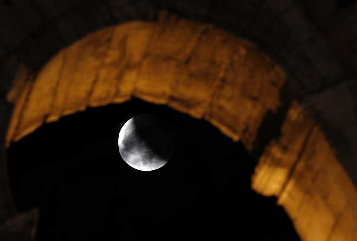 Лунное затмение в развалинах Колизея в Риме. ©REUTERS/Alessandro Bianchi