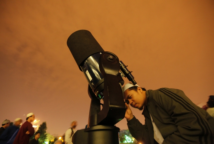 Наблюдение лунного затмения в телескоп, Куала-Лумпур, Малайзия. ©REUTERS/Bazuki Muhammad

