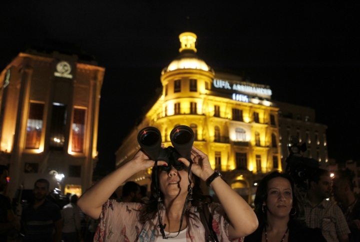 Девушка с биноклем наблюдает за лунным затмением  в Бейруте, Ливан. ©REUTERS/Jamal Saidi
