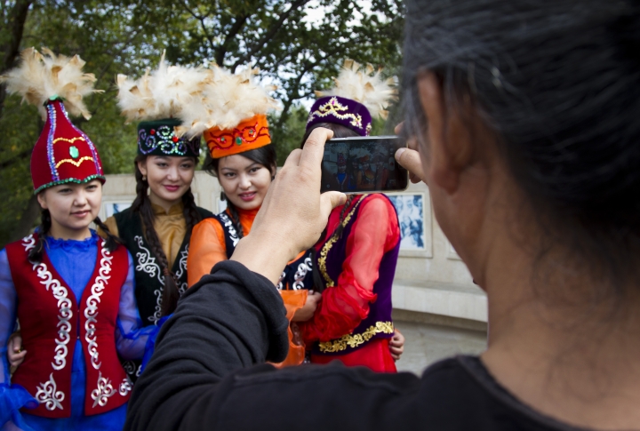 Корейский режиссер Ким Ки Дук фотографирует девушек в национальных костюмах на камеру своего мобильного телефона. <br>Фото: Владимир Дмитриев©