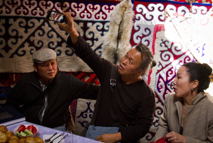 Корейский гость фотографирует внутреннее убранство казахской юрты. <br>Фото: Владимир Дмитриев©