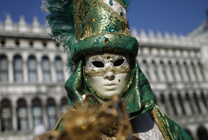 Участница карнавала в маске на площади Святого Марка в Венеции. Фото ©REUTERS