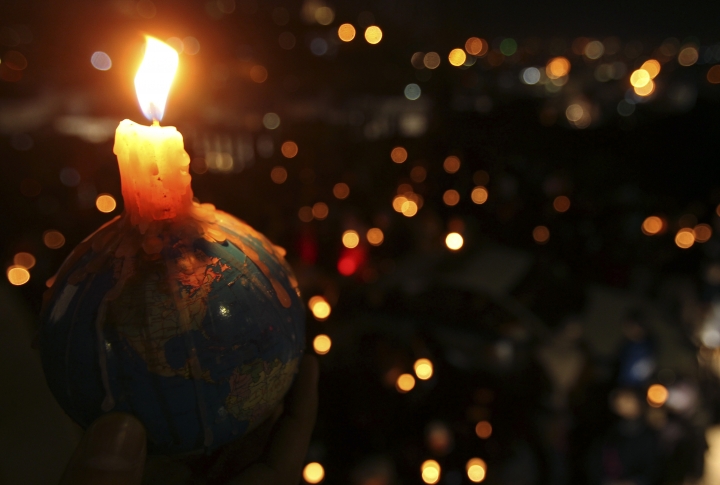 Подсвечник в форме глобуса, поддерживающий общую идею "Часа Земли". Фото REUTERS/Ali Jarekji©