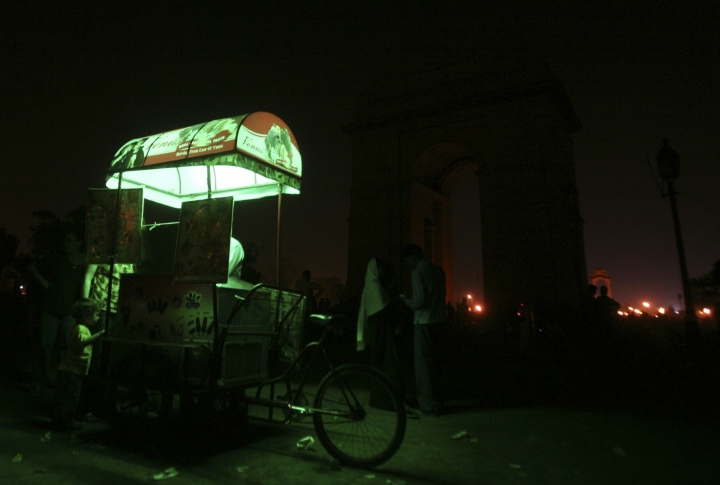 Тележка с мороженым на фоне отключенных от электрической подсветки "Ворот Индии" в Нью-Дели. Фото REUTERS/Parivartan Sharma©