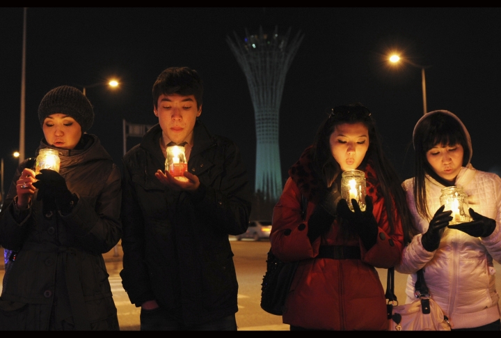 Астанчане со свечными фонариками на фоне "Байтерека" во время акции "Час Земли". Фото REUTERS/Mukhtar Kholdorbekov©