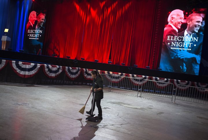 Женщина подметает сцену, с которой выступал Барак Обама. Фото ©REUTERS