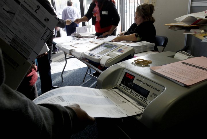 Бюллетень вставляют в машину для голосования. Фото ©REUTERS