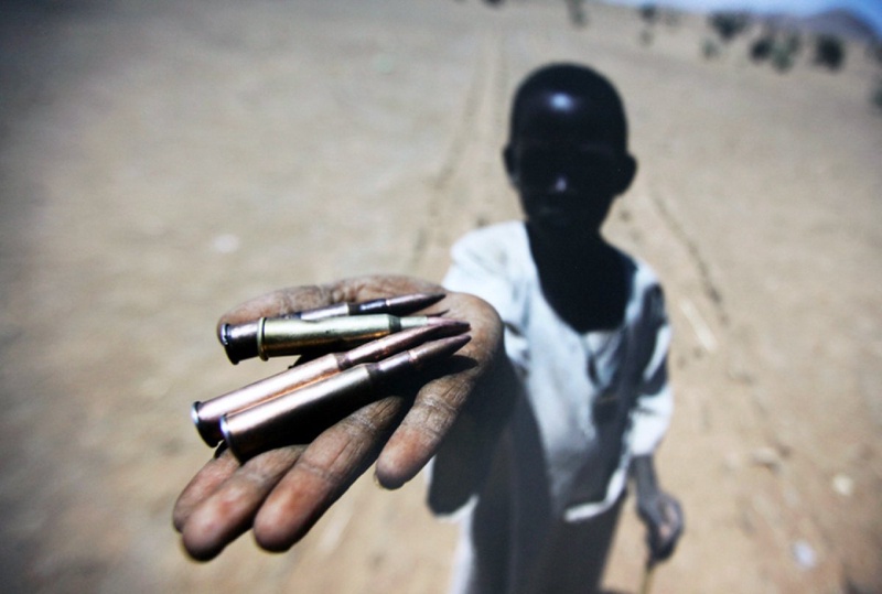 Ребенок держит в руках пули, собранные с земли в деревне Северного Дарфура. 27 марта 2011<br> Фото UN Photo/Albert Gonzalez Farran©