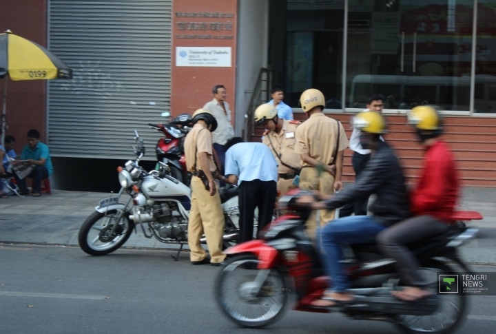 Дорожные полицейские Хошимина проверяют документы байкера. ©Роза Есенкулова