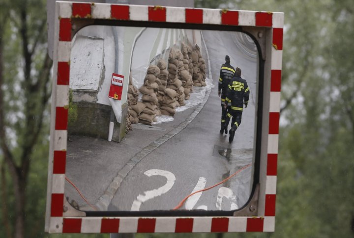 Спасатели проходят мимо мешков с песком для защиты здания от паводковых вод на одной из улиц в центре австрийского города Мельк, примерно в 100 км (62 милях) к западу от Вены (отражение в зеркале). Фото ©REUTERS