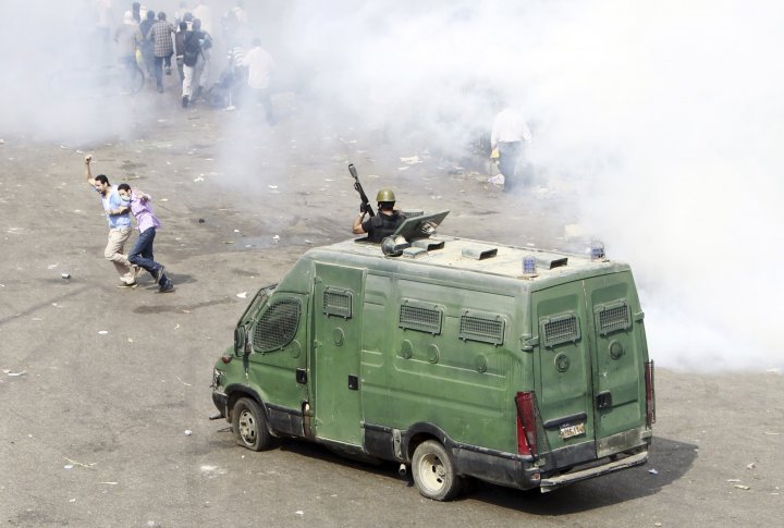 Cторонникb свергнутого президента Египта Мохаммеда Мурси бегут от слезоточивого газа и резиновых пуль полиции во время столкновений у Каирского университета 14 августа 2013 года. Фото ©REUTERS