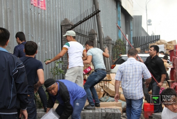 Коробки с обувью вытаскивают из рынка. Люди ломают железный забор. Фото Роза Есенкулова©