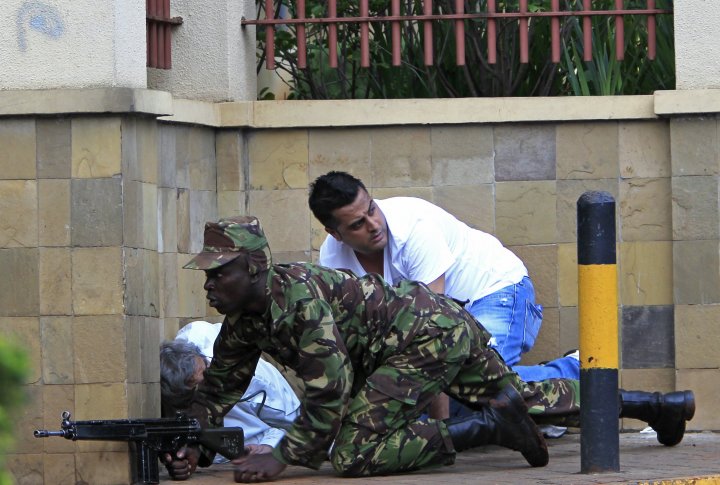 Кенийский солдат под прикрытием стены у торгового центра Вестгейт в Найроби 21 сентября 2013 г. Фото ©REUTERS