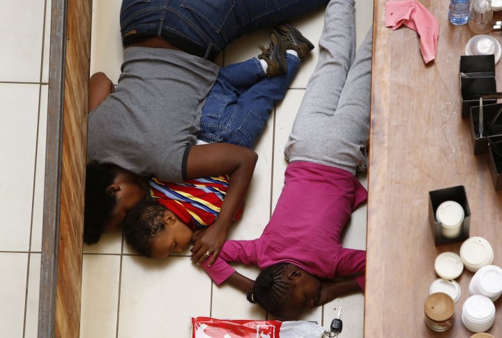 Мать и дети скрываются от боевиков в торговом центре Вестгейт в Найроби 21 сентября 2013 г. Фото ©REUTERS