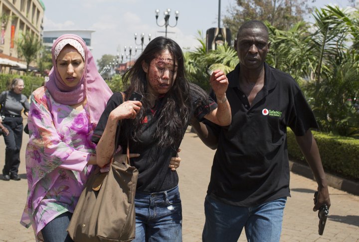Раненая женщина выходит из торгового центра Вестгейт в Найроби 21 сентября 2013 г. Фото ©REUTERS