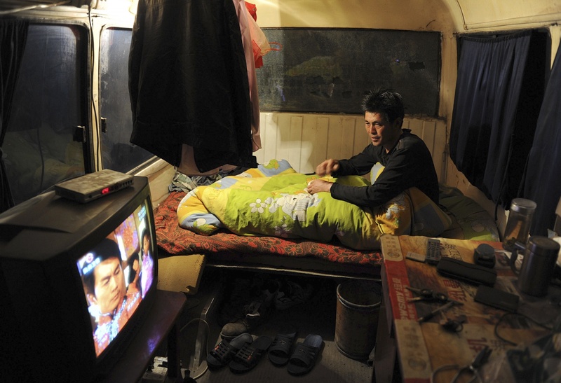 Китайский рабочий перед телевизором. Фото REUTERS/Jianan Yu©