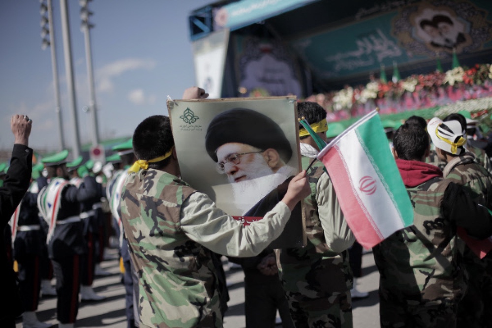 Участники демонстрации в 33-ю годовщину исламской революции держат плакат с портретом аятоллы Али Хосейни Хаменеи на площади Свободы в Тегеране. Фото РИА Новости