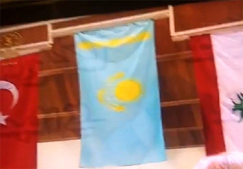 На турнире по пулевой стрельбе в Кувейте поднимают флаг Казахстана. Кадр видеоролика с Youtube