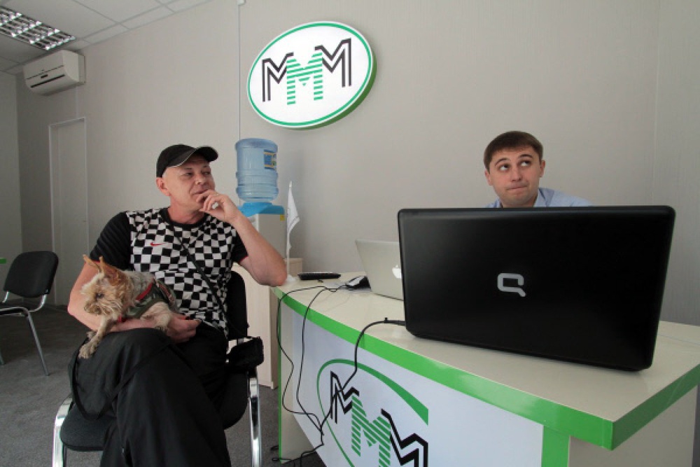 Клиент общается с сотрудником офиса компании "МММ 2011". Фото ©РИА НОВОСТИ