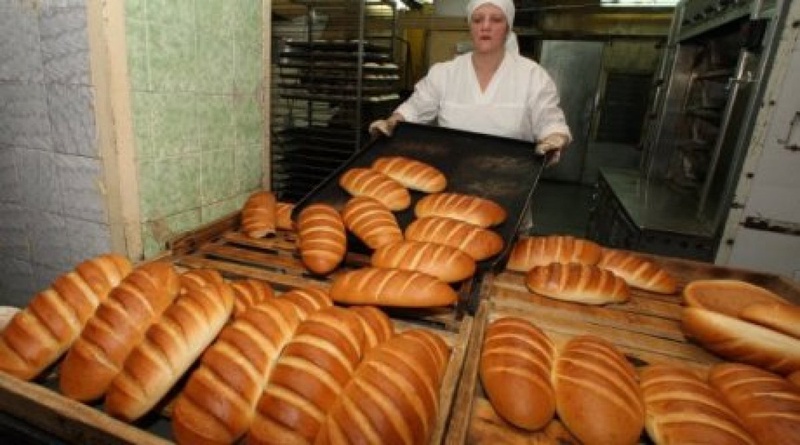  Работник пекарни укладывает готовые изделия на поддоны в цехе по выпуску хлебо-булочной продукции. Фото РИА Новости©