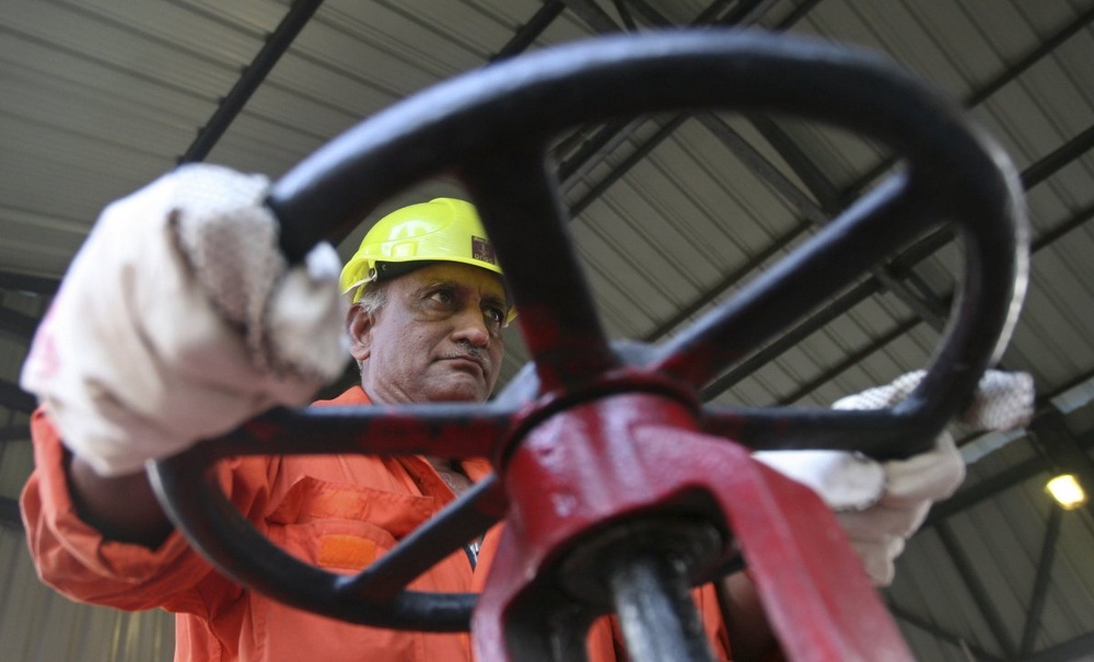 Техник индийской компании Oil & Natural Gas Corp открывает вентиль. Фото ©REUTERS
