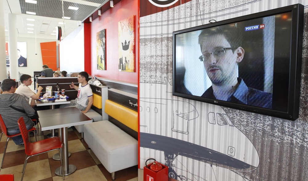 Эдвард Сноуден на экране телевизора в аэропорту Шерметьево. Фото ©REUTERS