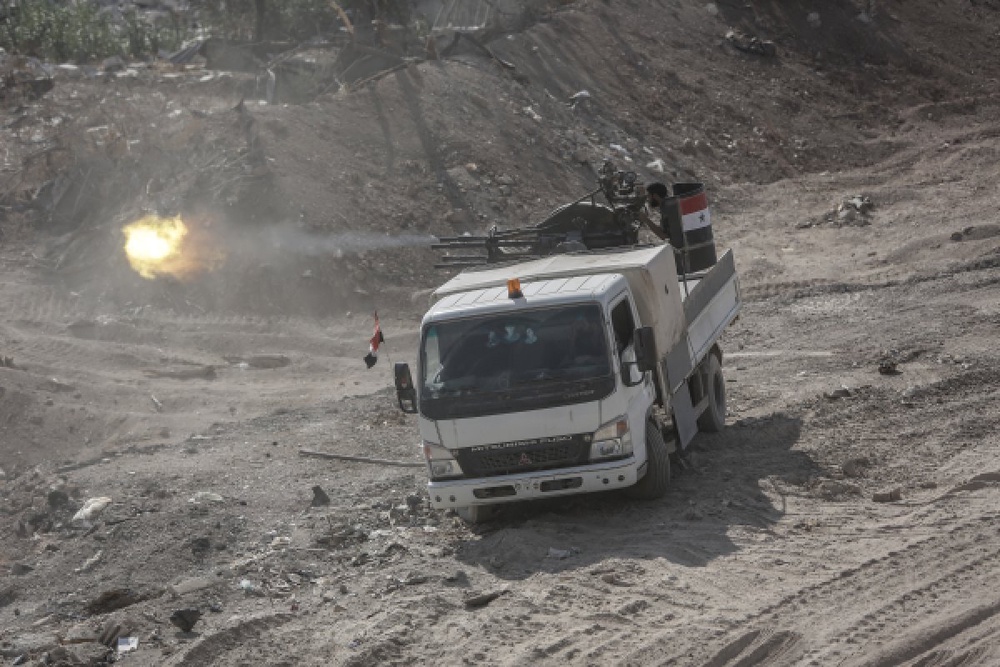 Военнослужащие сирийской армии ведут огонь из зенитного пулемета по мятежникам в пригороде Дамаска. Фото ©РИА Новости