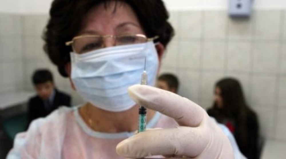Врач приготавливает инъекцию для прививки в школьном медпункте. Фото ©РИА Новости