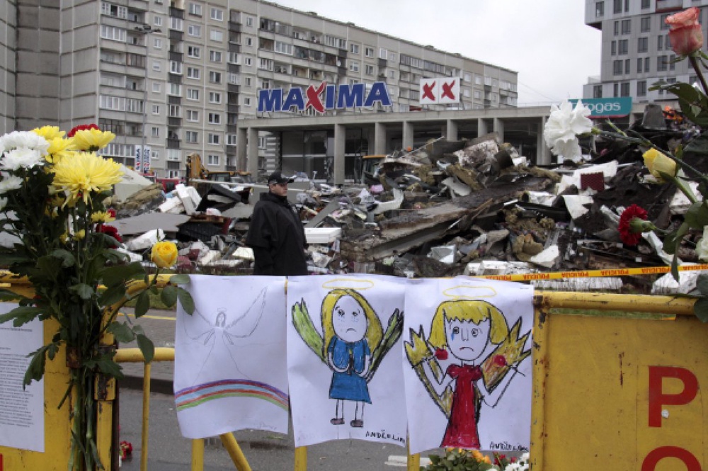 Цветы и детские рисунки на месте трагедии у торгового центра Maxima. ©РИА Новости
