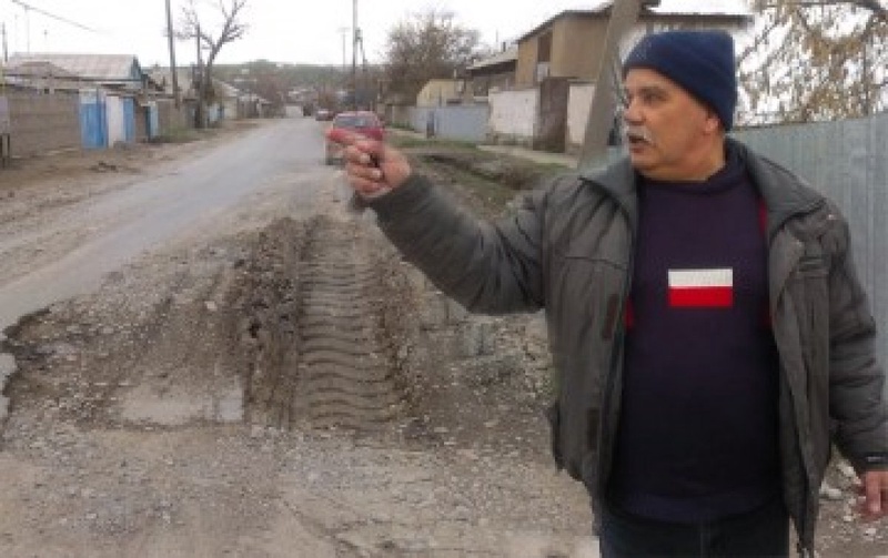 Местный житель рассказывает об ужасных дорогах города. Фото с сайта Otyrar.kz