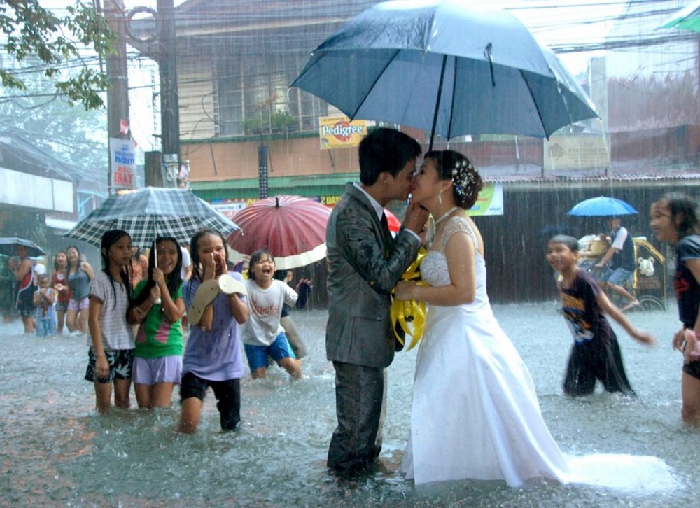 Пара целуется под дождем в Маниле.
