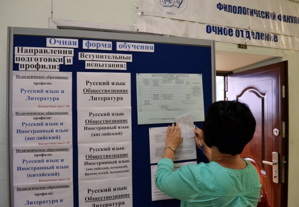 Абитуриентка смотрит информацию на стенде. ©РИА Новости