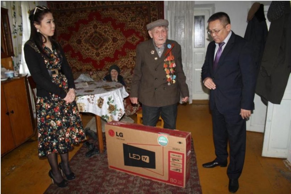 Представители ДГД по Жамбылской области дарят ветерану подарки. Фото предоставлено пресс-службой Комитета государственных доходов МФ РК.