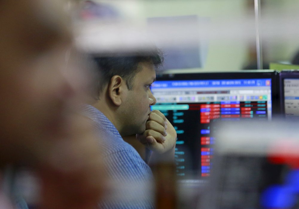 Трейдер перед экранами компьютеров на бирже. Фото © REUTERS