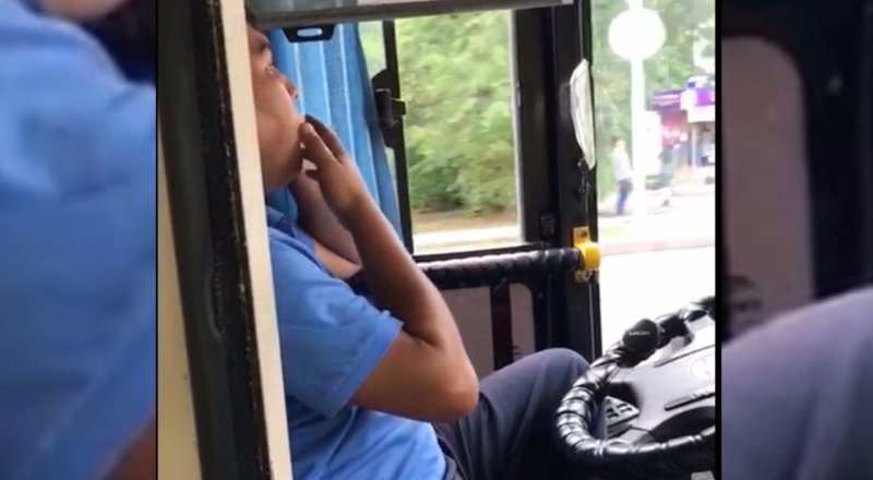 Водитель автобуса разговаривает по телефону и курит за рулем