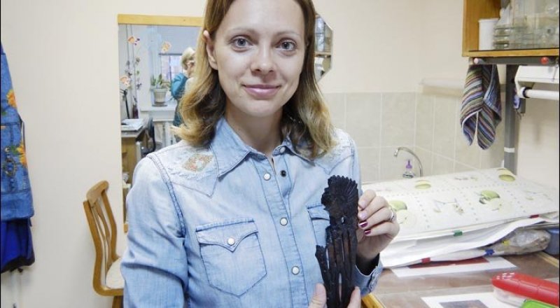 Археолог Наталья Басова держит в руках загадочный артефакт. © siberiantimes.com
