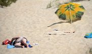Летящий по ветру зонт пронзил гулявшую по пляжу женщину